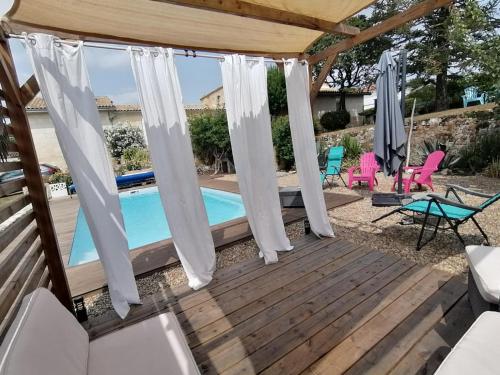 une terrasse en bois avec une piscine et un kiosque dans l'établissement Les Agapanthes - Adult only, à Montagne