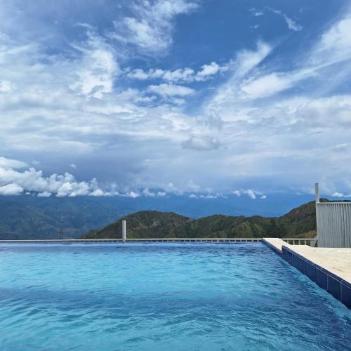 a swimming pool with mountains in the background at Glamping del Occidente in Cativo