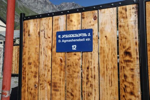 a sign on a wooden fence with a sign on it at Cottages DILA in Stepantsminda