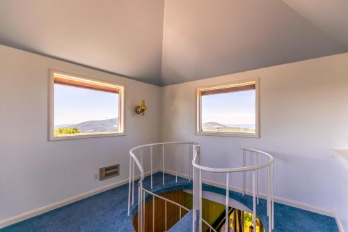 a spiral staircase in a room with two windows at Endless Vistas in Seven Devils