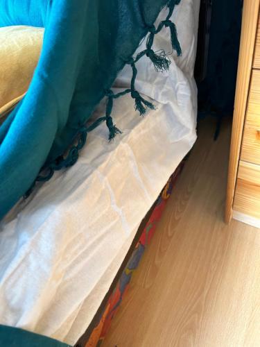 a bed with a blue sheet on top of it at Studio la Gioia in Allos