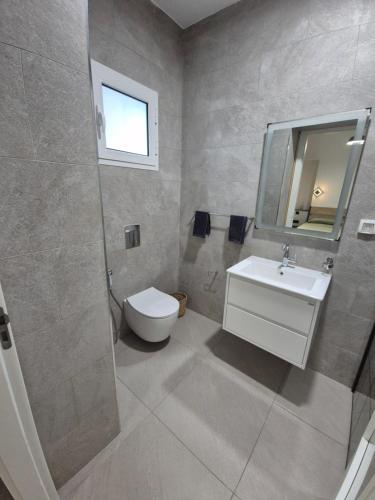 a bathroom with a toilet and a sink and a mirror at Maison moderne avec Piscine et accès plage - Résidence Jinen Hammamet in Hammamet Sud