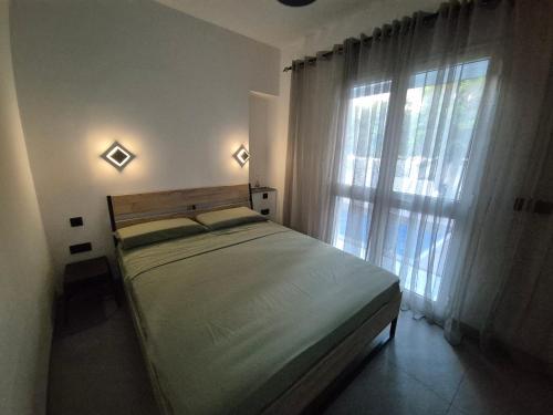 a bedroom with a bed and a large window at Maison moderne avec Piscine et accès plage - Résidence Jinen Hammamet in Hammamet Sud