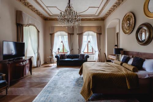 a living room with a bed and a chandelier at Pałac Mojęcice in Mojęcice