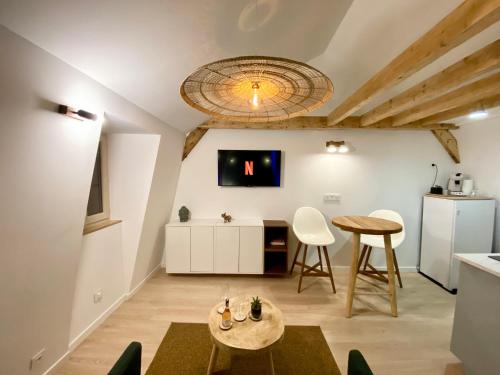 - un salon avec une table, des chaises et une télévision dans l'établissement Maison De Charme - 2 Suites Deluxe - Brive Centre Historique, à Brive-la-Gaillarde