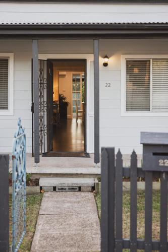 a front door of a white house with a fence at Halcyon Days your perfect getaway Sunday late check out, pet friendly! in Cessnock