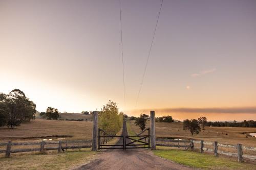 an open gate in a field with a fence at Halcyon Days your perfect getaway Sunday late check out, pet friendly! in Cessnock