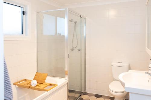 a bathroom with a shower and a toilet and a sink at Halcyon Days your perfect getaway Sunday late check out, pet friendly! in Cessnock
