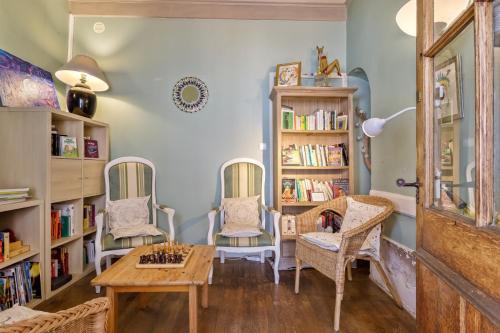 a room with two chairs and a table and bookshelves at Gîte de groupe Val dOrey in Ruffieu