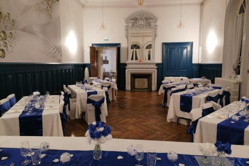 a room filled with tables with white and blue linens at Gîte de groupe Val dOrey in Ruffieu