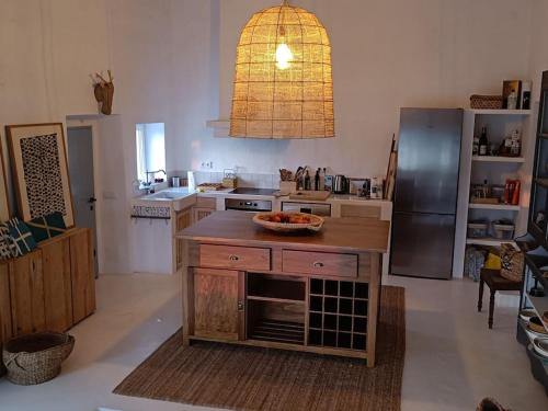 una cocina con nevera y una mesa con un tazón. en Casa dos Bonitos, en Santa Susana
