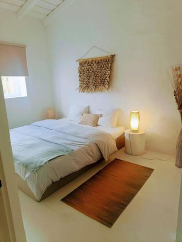 a bedroom with a bed with a rug and a lamp at Casa dos Bonitos in Santa Susana