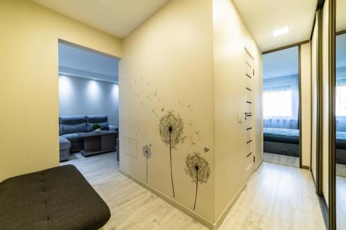 a living room with a wall with dandelions on it at Amber Apartments in Šiauliai
