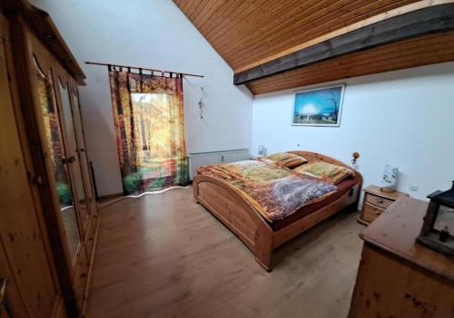 a bedroom with a bed and a wooden ceiling at Ferienwohnung Heckenäcker in Ortenberg