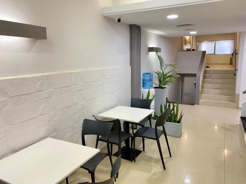 a restaurant with white tables and chairs and stairs at ALWA Suites in Resistencia