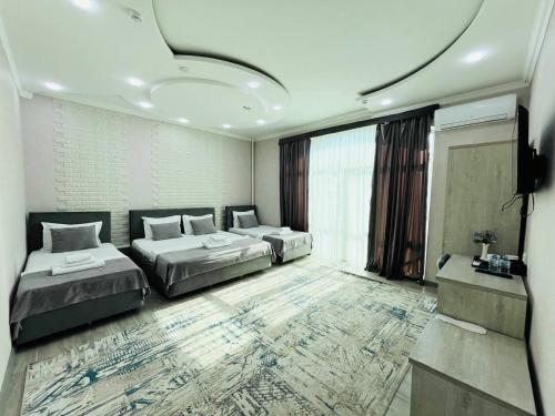 een slaapkamer met twee bedden en een groot raam bij Hotel Shosh Boutique in Tasjkent