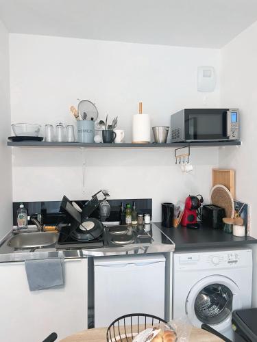 une cuisine avec une cuisinière et une machine à laver dans l'établissement L'appartement du golf- terrasse et jardin privé, à Bussy-Saint-Georges