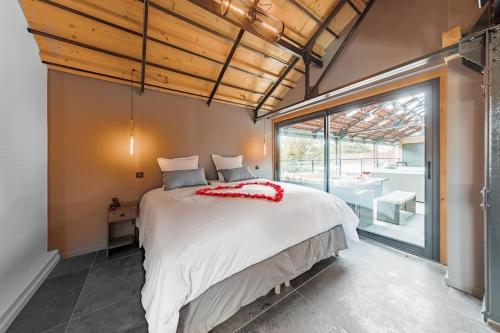 une chambre avec un grand lit et une grande fenêtre dans l'établissement La Limonaderie, Loft avec Jacuzzi, à Pont-à-Mousson