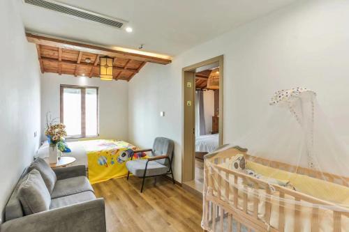 a room with a crib and a bedroom at Wuzhen Residence B&B in Tongxiang
