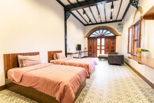 a bedroom with two beds and a window at ROSE - Fong Lee CC Lampang Walking Street in Lampang