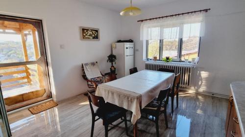 a kitchen with a table and chairs and a refrigerator at Ana House in Daia Romînă