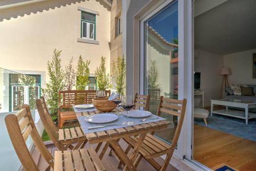 a dining table and chairs in a room with a patio at Urban Beach Estoril Apartment in Estoril