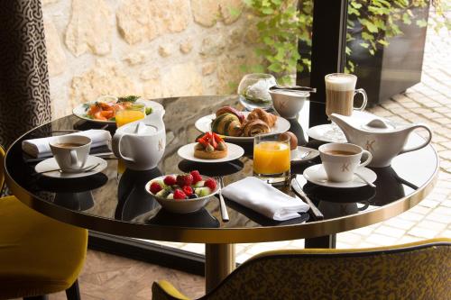 a breakfast table with breakfast foods on it at Domaine de la Klauss & Spa, Restaurant Gastronomique Le K in Montenach
