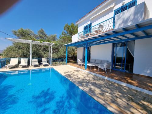 a swimming pool in front of a house at Olive Beach Villa in Peyia