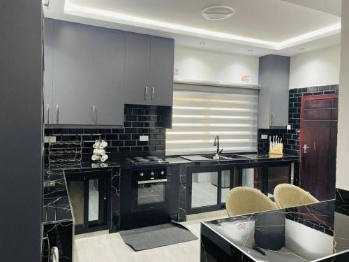 a kitchen with black counter tops and appliances at Peaceful escape in the middle of nowhere in Lusaka