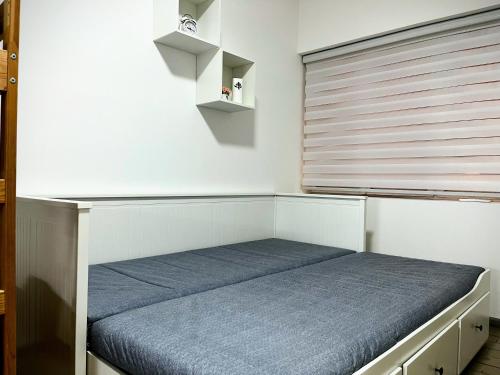 a bed in a room with a window with a blue mattress at Apartman Vanila in Bela Crkva