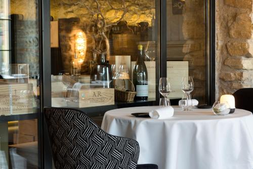 a table with two wine glasses on top of it at Domaine de la Klauss & Spa, Restaurant Gastronomique Le K in Montenach