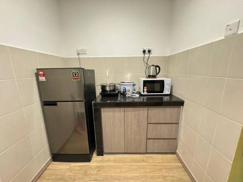 una piccola cucina con frigorifero e forno a microonde di Eisya Homestay Emerald Avenue Brinchang a Brinchang