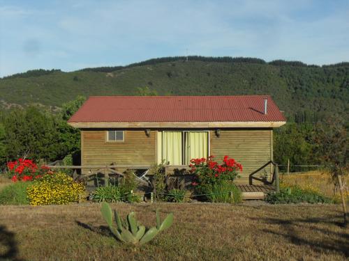 a small house with a red roof in a yard at Hostal La Maravilla in Vilches