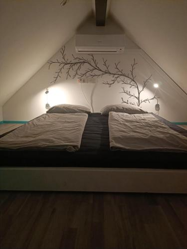 a bedroom with a bed with a tree mural on the wall at Apartment Loft Pejić - open space loft studio near Bovec, Soča Valley in Bovec