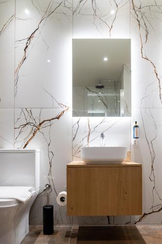 a bathroom with a sink and a mirror at Ciel Living Athens in Athens