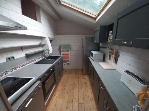 une cuisine avec des appareils en acier inoxydable et une lucarne dans l'établissement Agréable maison de ville avec cheminée, à Luchon