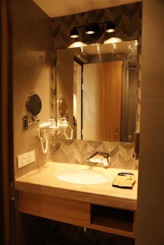 a bathroom with a sink and a large mirror at The Grand Sona in Deoghar