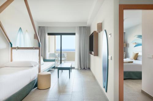 a hotel room with two beds and a table at Iberostar Waves Gaviotas Park in Morro del Jable