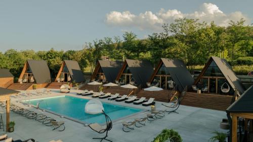 a resort with a swimming pool and lounge chairs at Ikalto Woods in Tʼelavi