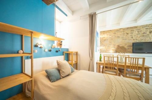 une chambre avec un lit et une salle à manger dans l'établissement Chaumière des Dunes à 350m de la plage de Kerhillio, à Erdeven