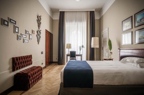 a hotel room with a bed and a chair at Grand Hotel et de Milan - The Leading Hotels of the World in Milan