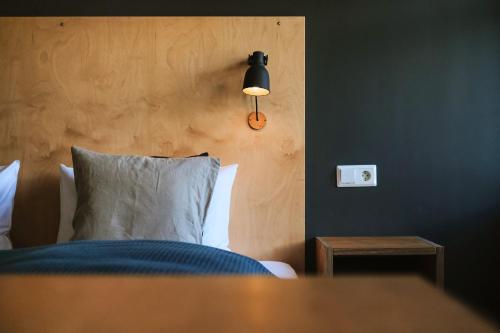 a bedroom with a bed with a light on the wall at Snæfell - Hotel by Aldan in Seyðisfjörður