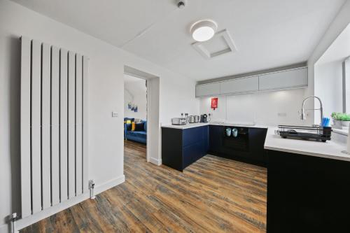 a kitchen with white walls and a wooden floor at Host & Stay - The Staffordshire Knot in Buxton