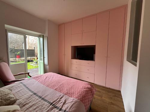 - une chambre avec un lit et une télévision dans une armoire dans l'établissement Appartement Solidor 50m2 et jardin à deux pas des plages, à Saint-Malo