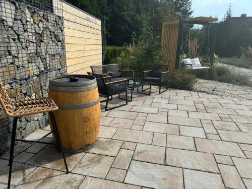 a barrel on a patio with chairs and a table at Vegas Hriňová Penzión in Hriňová