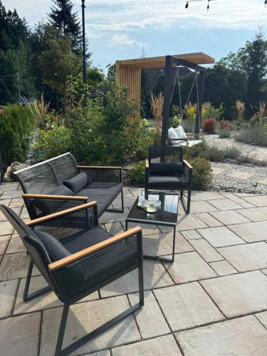 a patio with two chairs and a couch and a table at Vegas Hriňová Penzión in Hriňová