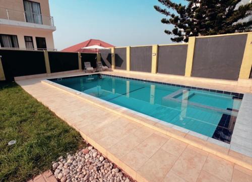 a swimming pool in front of a house at Novella Apartments in Kigali