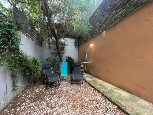 a patio with two chairs and a table and a tree at Apartamento El Mirador de La Farga in Arbúcies