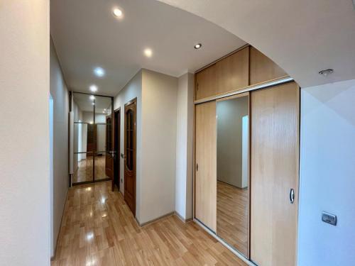 an empty hallway with wood flooring and glass doors at sairan comfort in Almaty