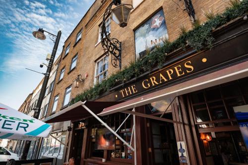 a building with a sign on the front of a store at The Grapes Pub in Southampton